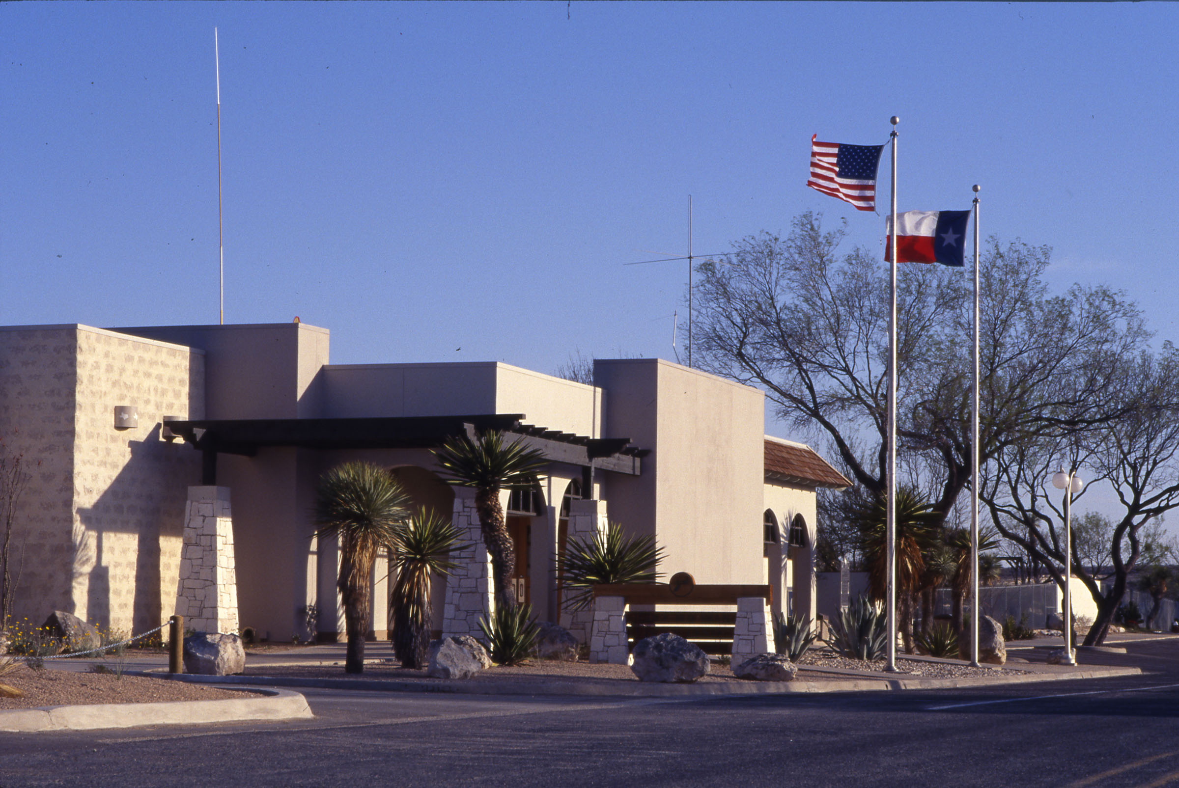 The exterior of a building flying a Texas and United States flag