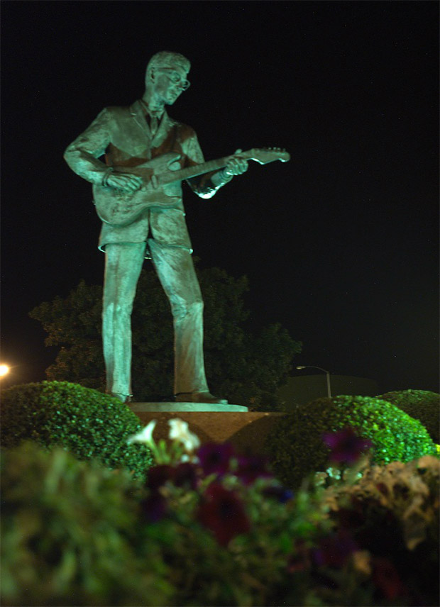 A picture of the Buddy Holly statue in Lubbock lit up at nighttime
