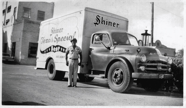 Lontime Spoetzl Brewery employee Calvin Cosmo Wallace stands proudly before one of the trucks he drove for the brewery. (Photo exerpted from the book Shine On: 100 Years of Shiner Beer by Mike Renfron)