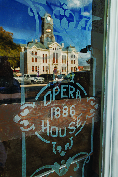 A window of the newly renovated Granbury Opera House reflects the facade of the 1891 Hood County Courthouse in Granbury.