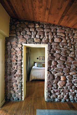 At Stone Village Tourist Camp in Fort Davis, a rock-covered wall in a garage space- turned-suite,
