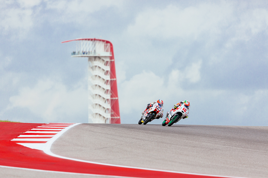 Moto3 riders Tony Arbolino and Gabriel Martinez come over the hill at Turn 10 with the iconic COTA tower in the background.