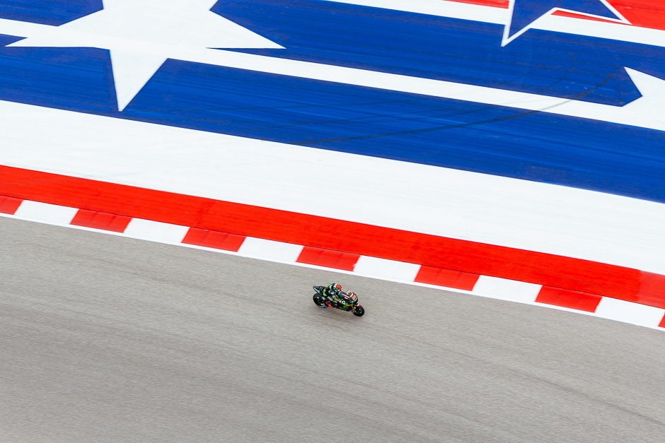 Monster Yamaha's Jonas Folger between turns 16 and seventeen as seen from the COTA tower viewing platform against the tracks signature red, white, and blue run-off area.