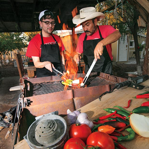 Rodrigo “T-rod” Trevizo shows son Brandon how to properly roast ingredients for a roasted chili salsa.