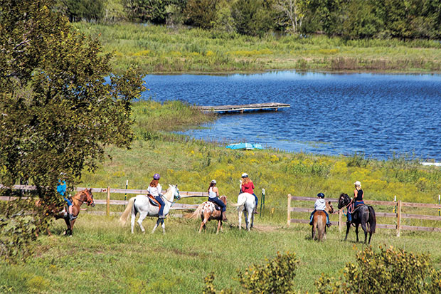 Horseback riders looking at a lake