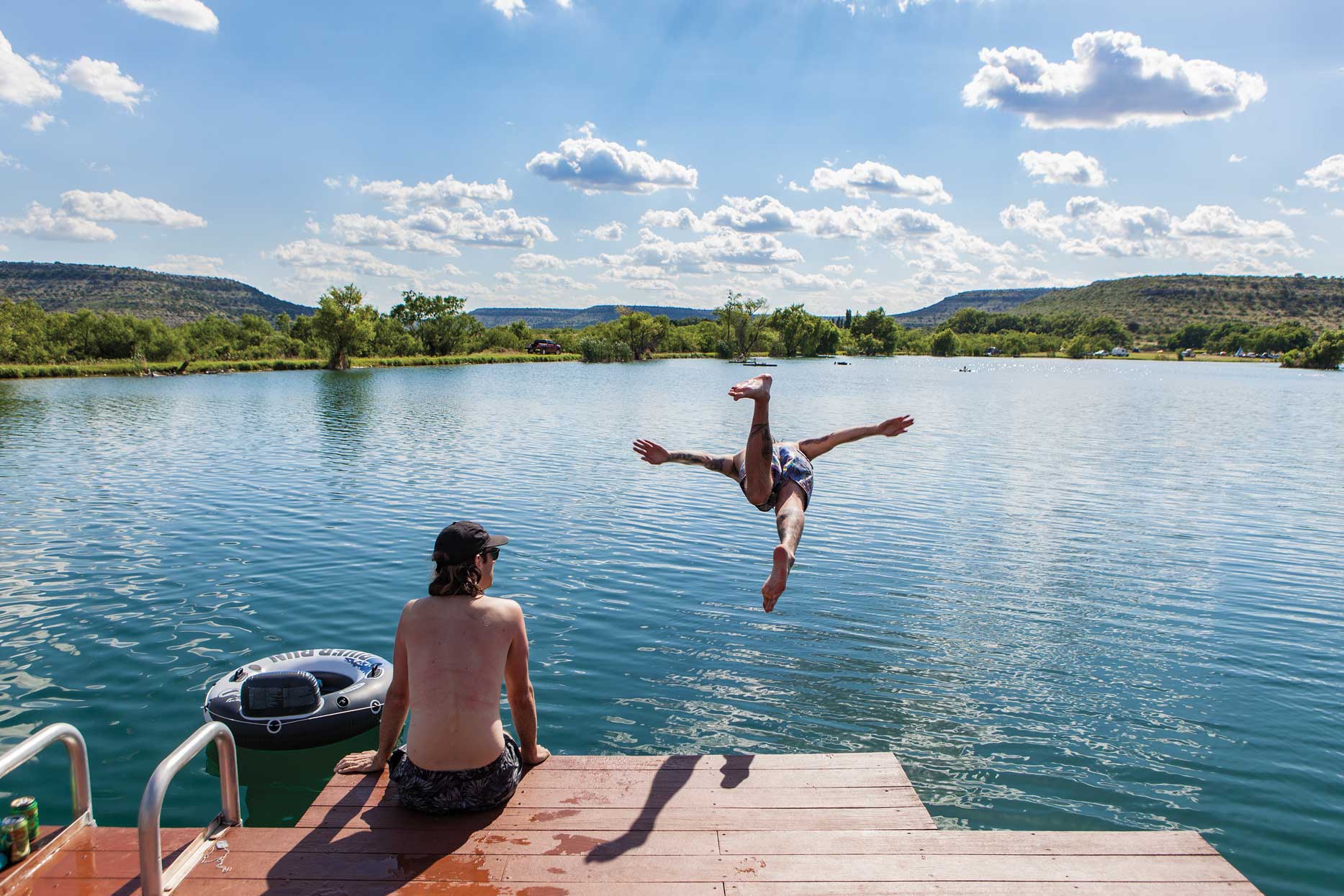 Swimmers dive into the lake at Independence Creek Preserve