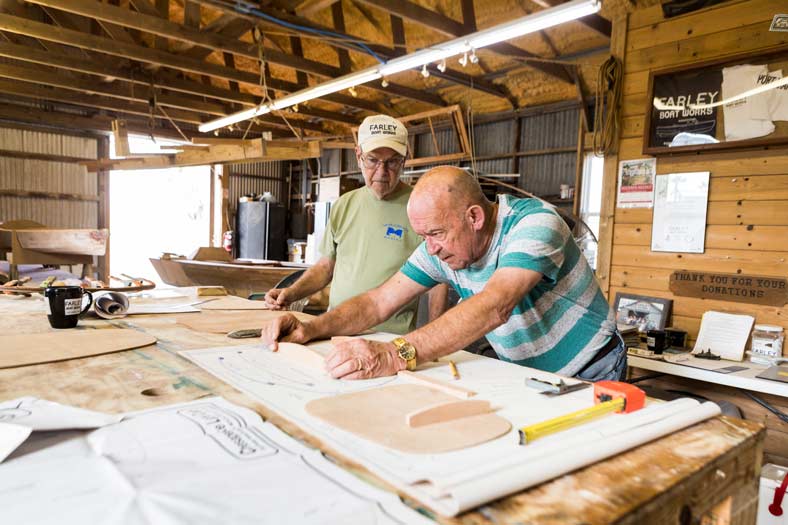 Men working on boat designs at Farley Boat Works