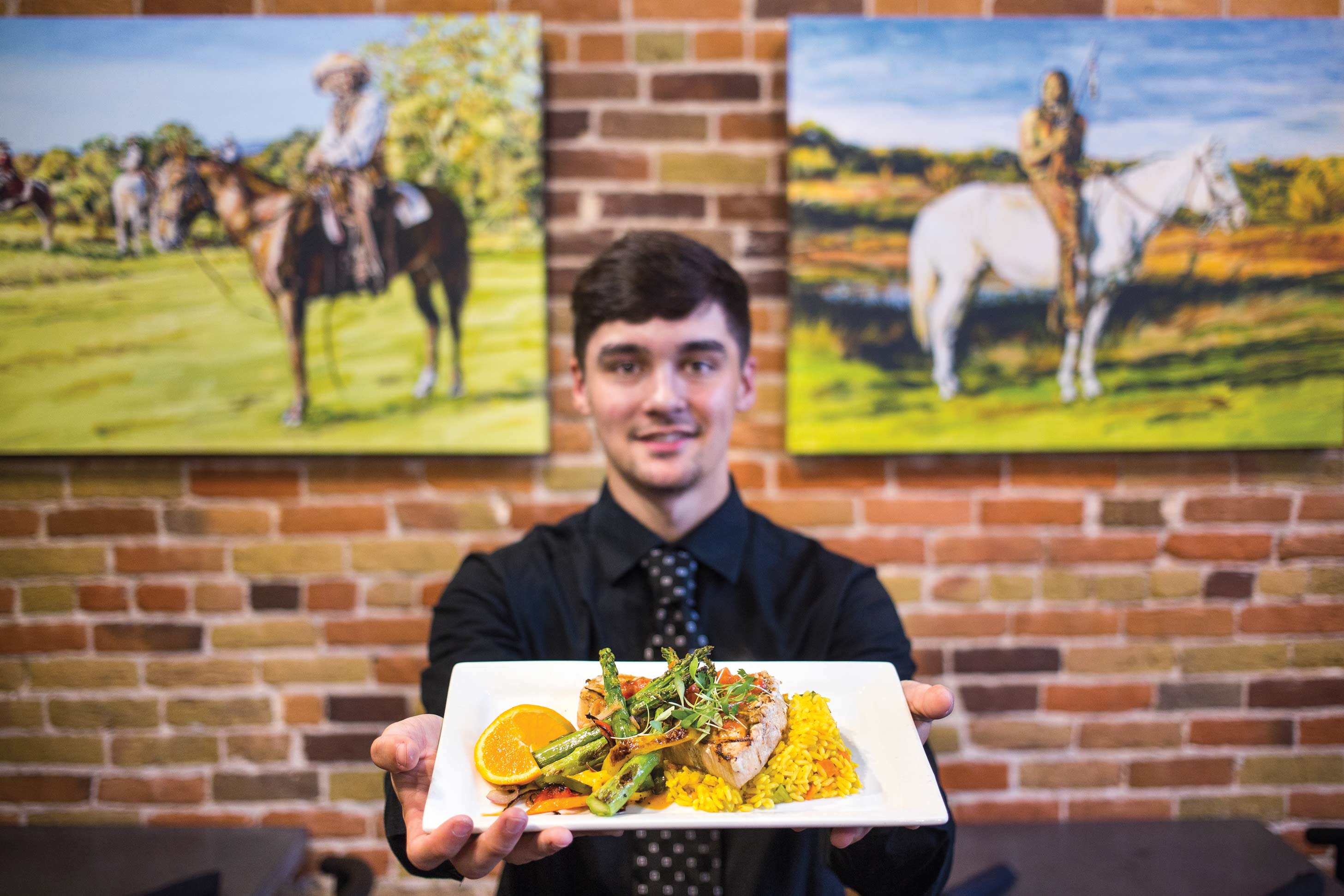 A server holds grilled swordfish at Ninety Six West restaurant