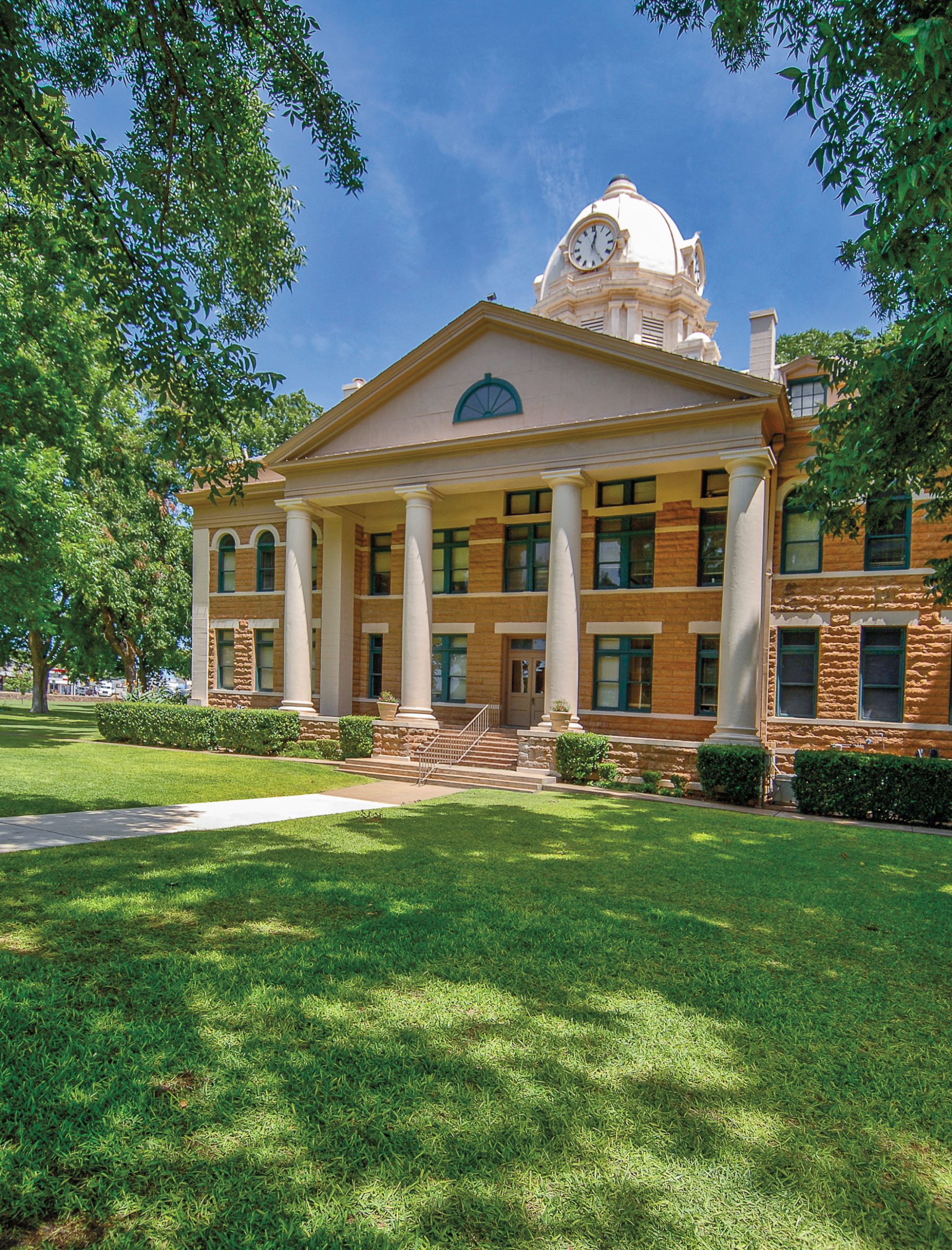An old courthouse in a lush green environment