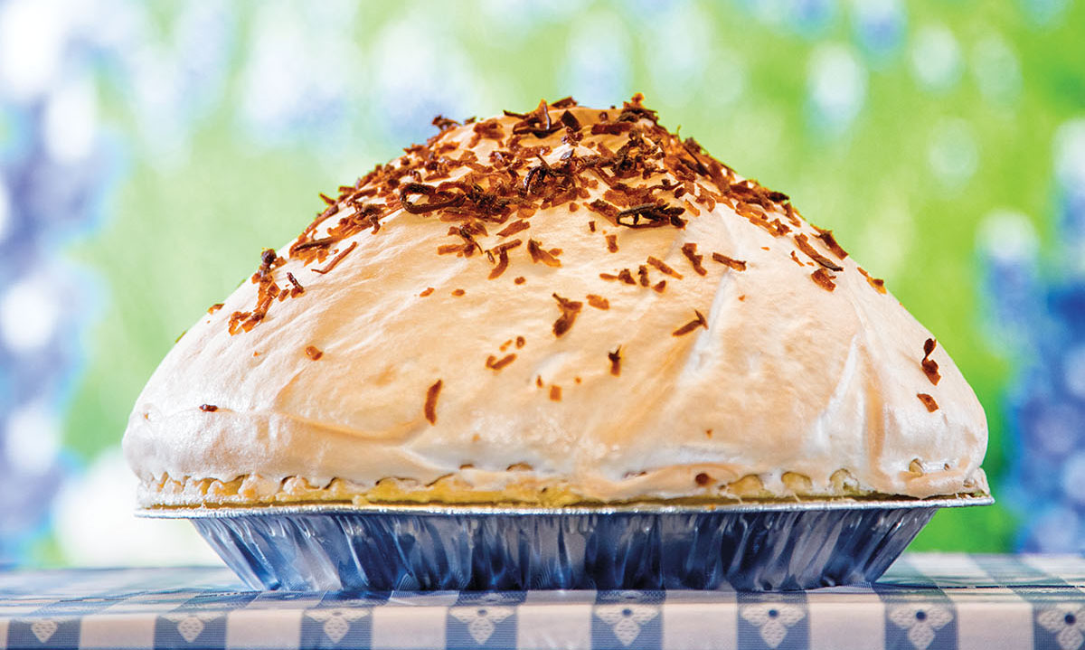 An alumnium pie plate piled high with pie, whipped cream, merangue and a topping