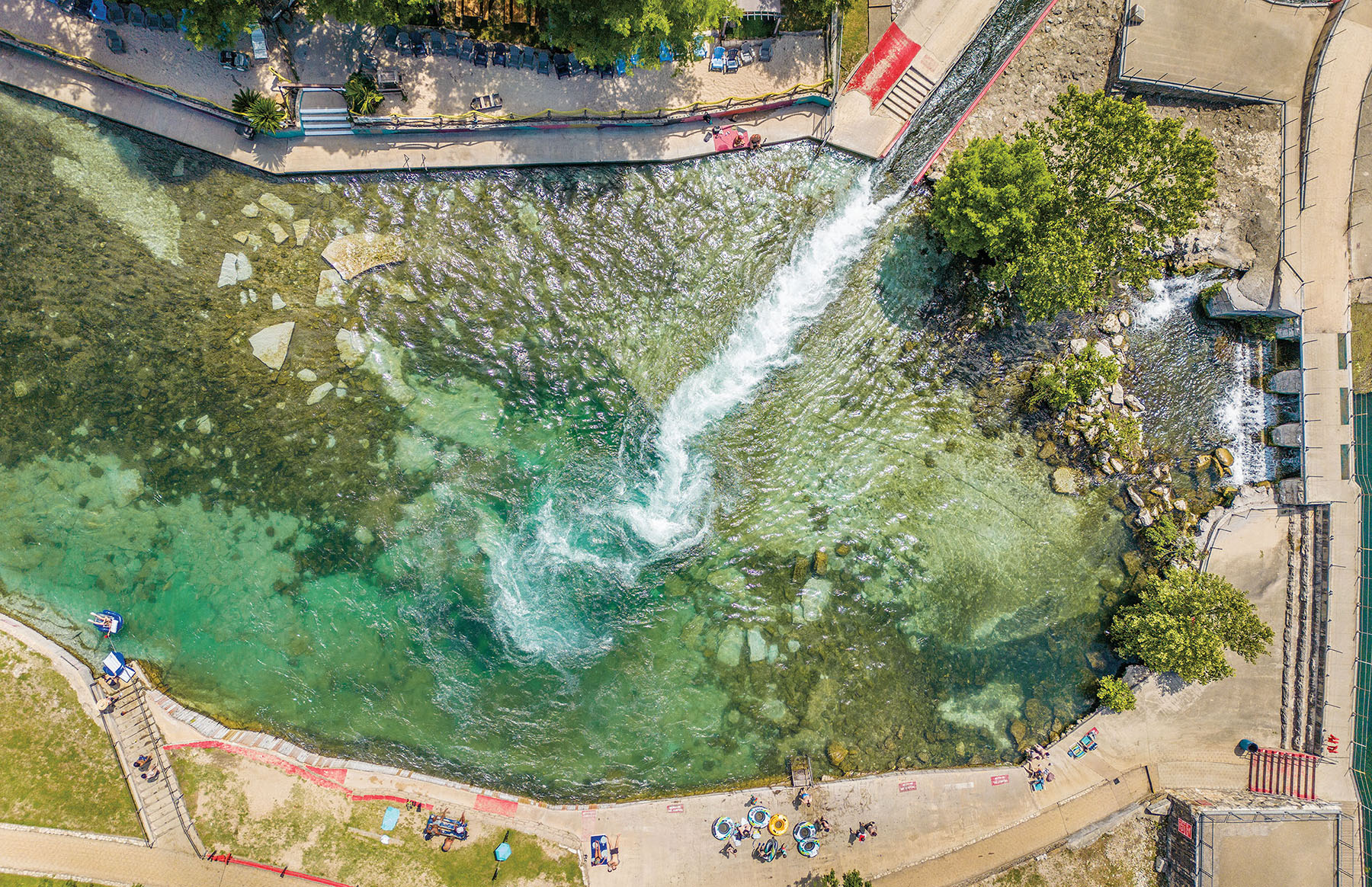 An overhead view of people swimming and relaxing in a spring-fed pool