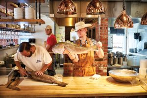 Chefs prepare a large, fresh-caught fish