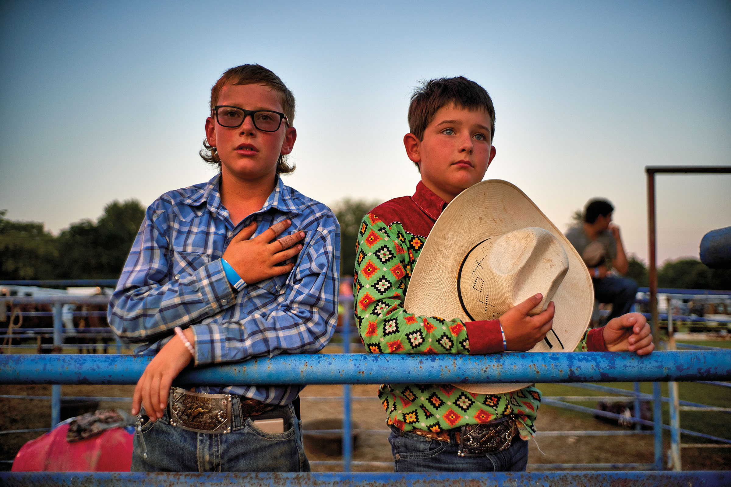 Two young men cover their hearts during the Naples Watermelon Festival and Rodeo