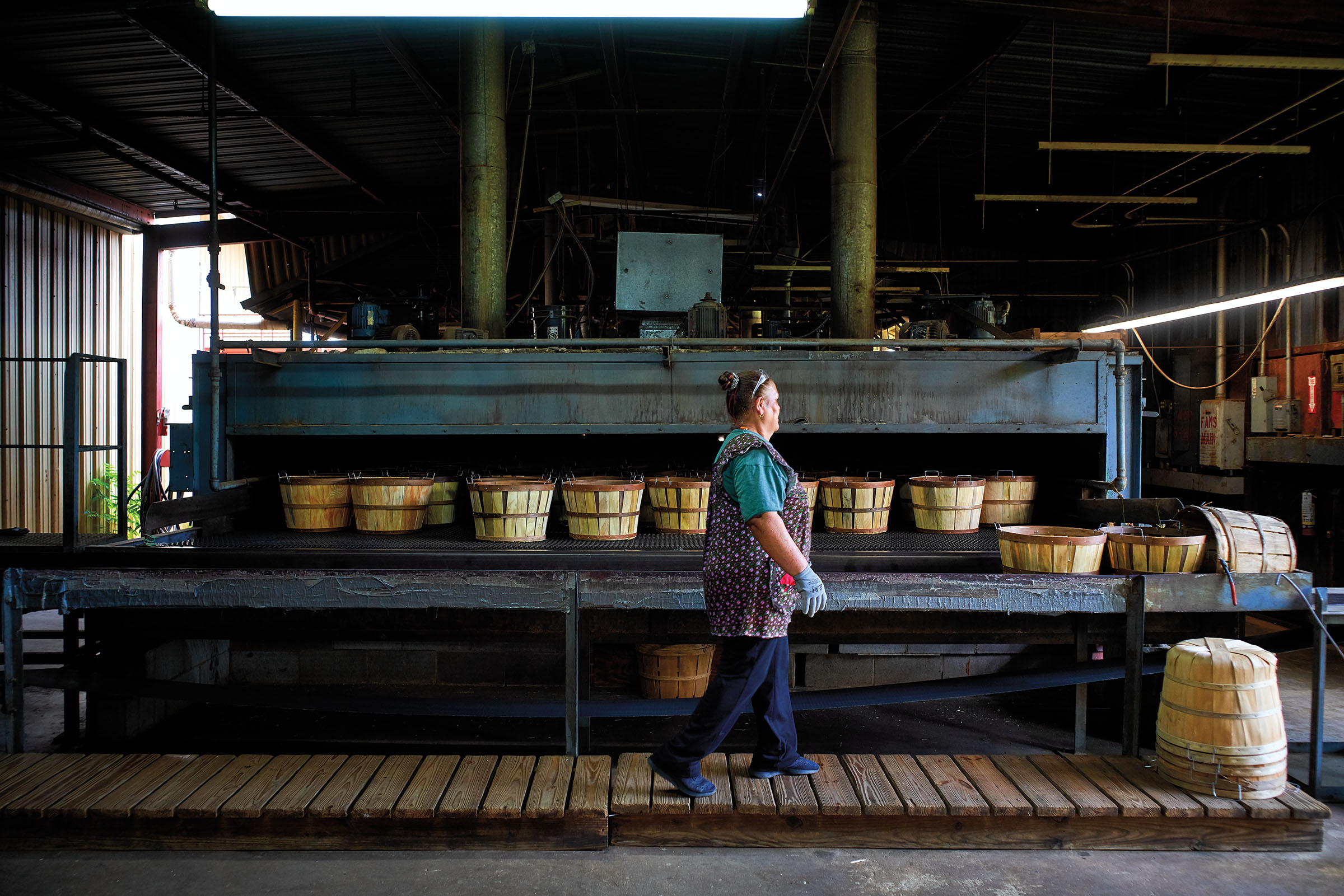 An employee organizes baskets as they enter the drying oven at the Texas Basket Factory in Jacksonville