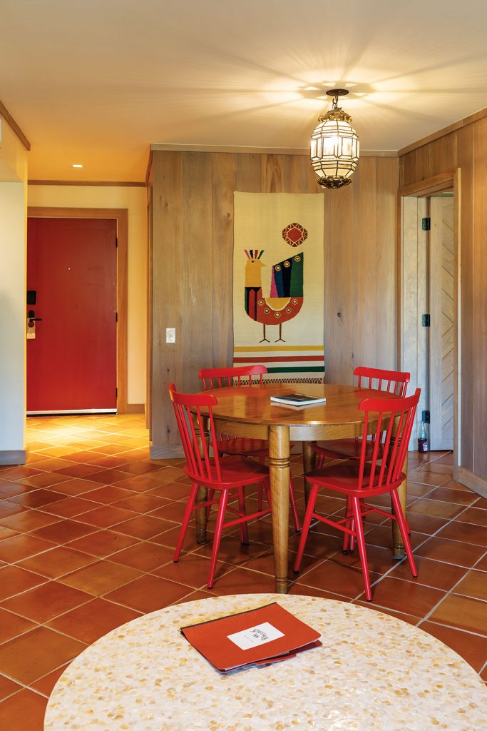 A ranch-style guestroom featuring red chairs, modern art and a tile floor at The Stagecoach