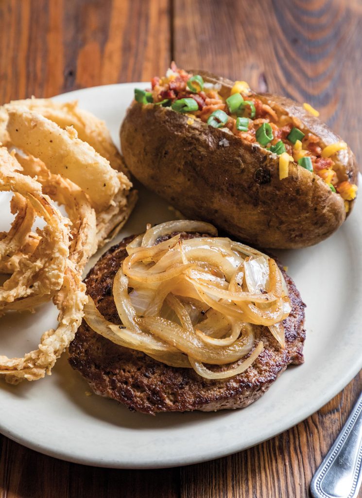 Original Alvin's Pepper Steak with onion rings and a baked potato at Hermann Sons in Hondo Texas