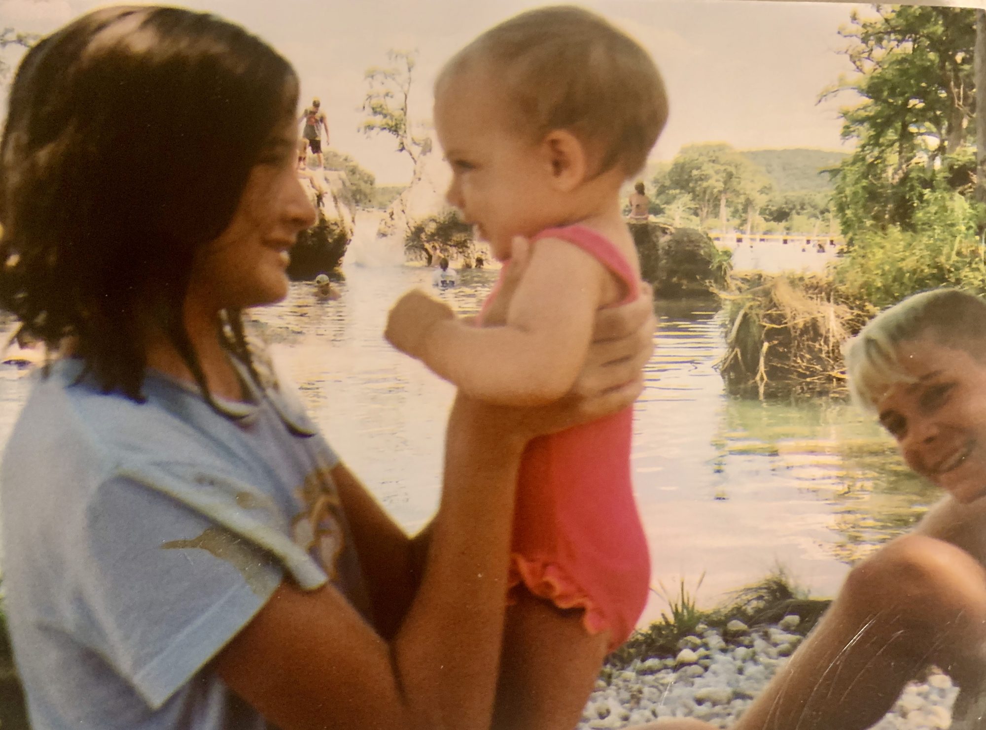 A woman holds a baby near the Frio River of Texas