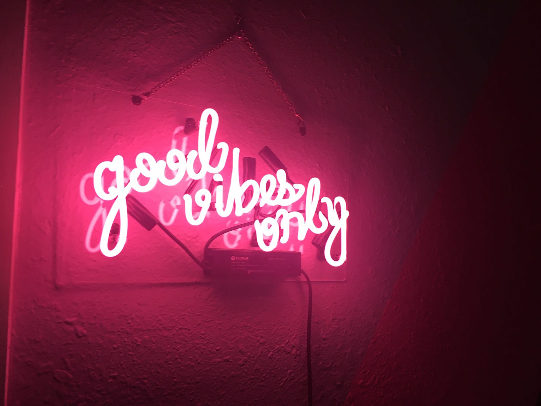 A neon Good Vibes Only sign in millennial pink.
