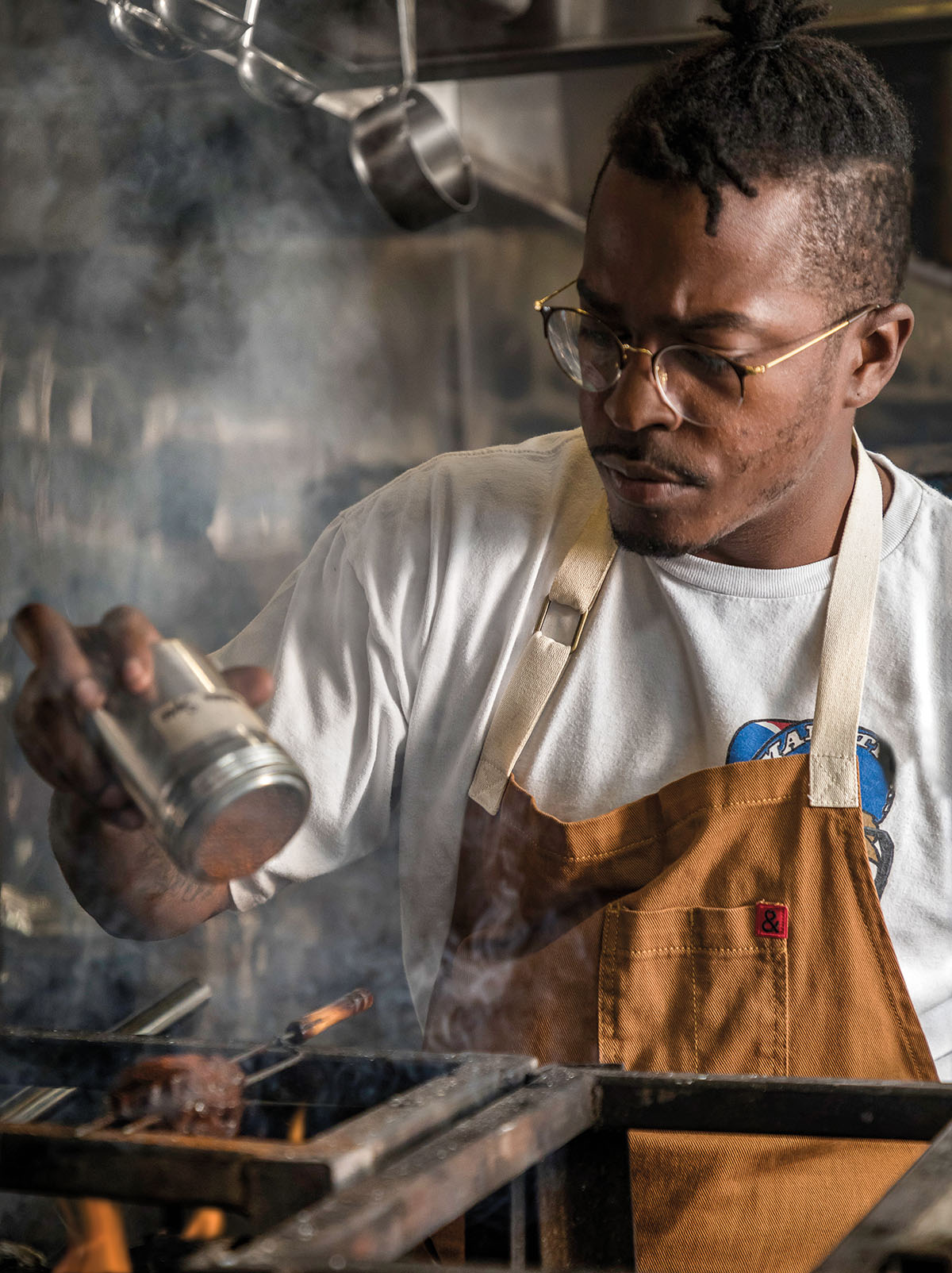 Chef Jonny Rhodes working in his live-fire kitchen in Houston, Texas