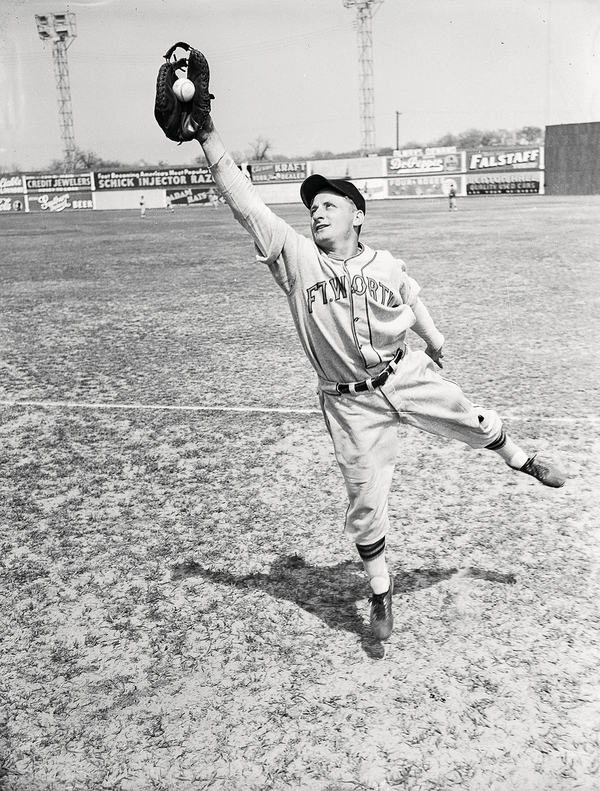 A man catches a baseball while playing for the Fort Worth Cats in 1940