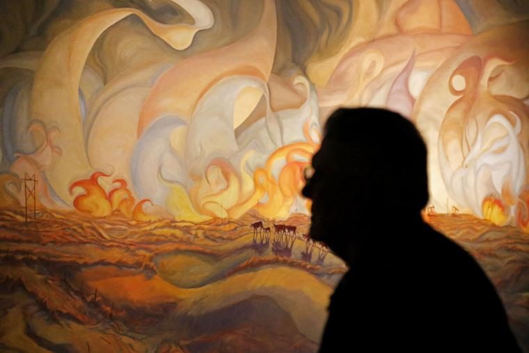 Man walks in front of "Frying Pan Fire" painting