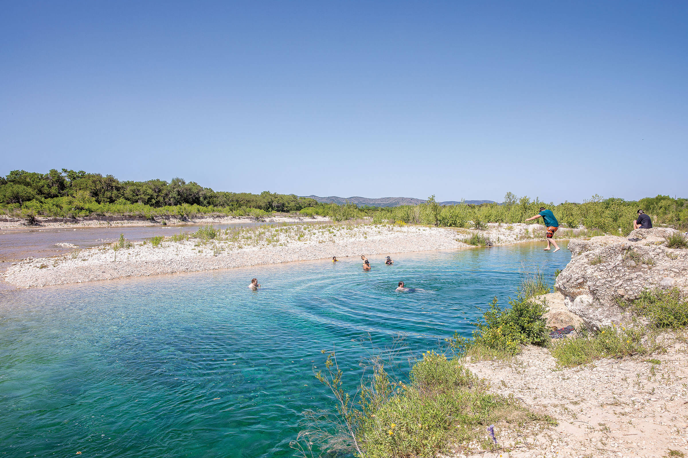 Various people wade and swim into The Quince on the Nueces River