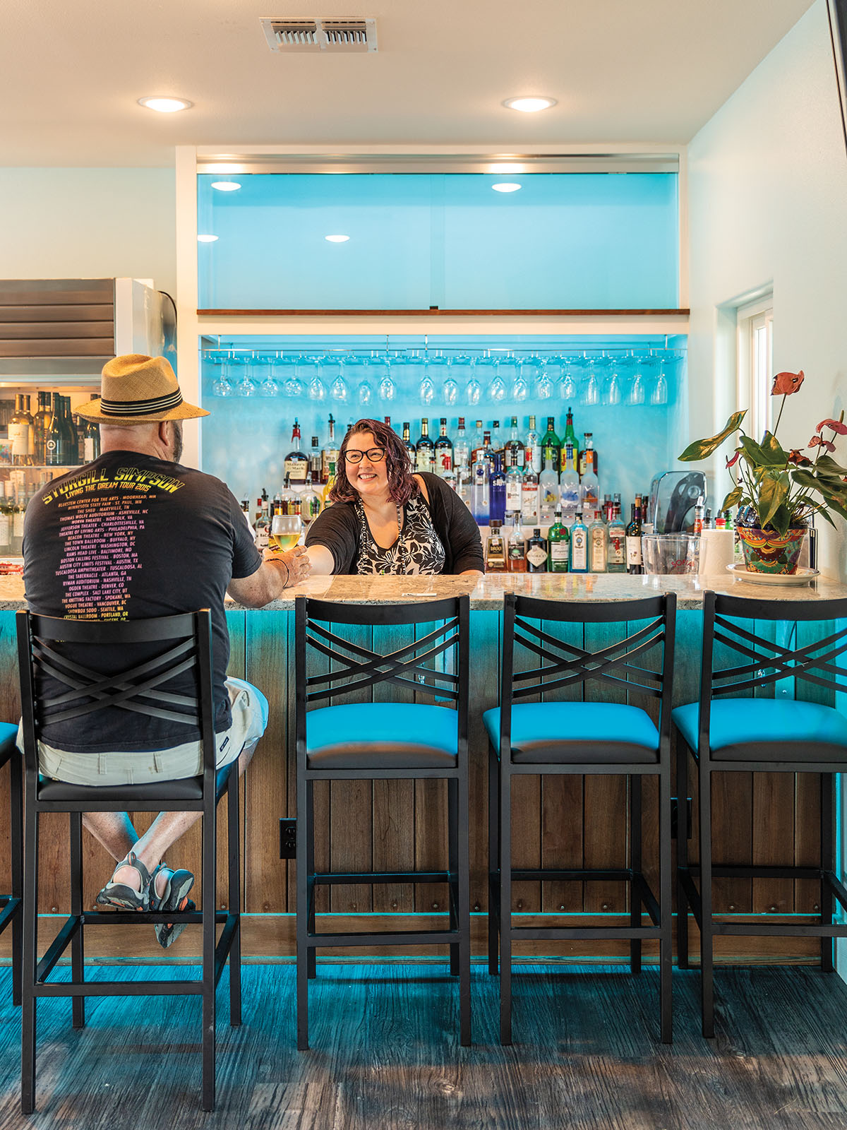 Natassia Brooks serves a drink to a man seated at the bar at Crab-N restaurant in Aransas Pass, Texas