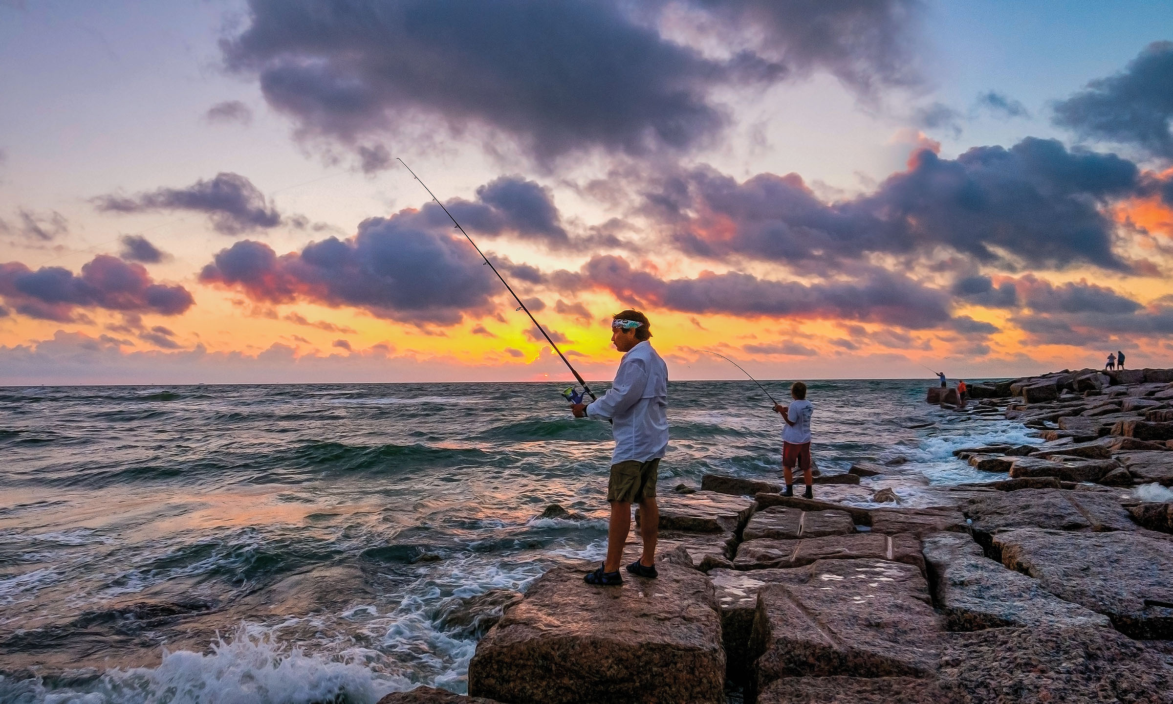 Fishermen cast their lines at sunset on Mustang Island, Texas