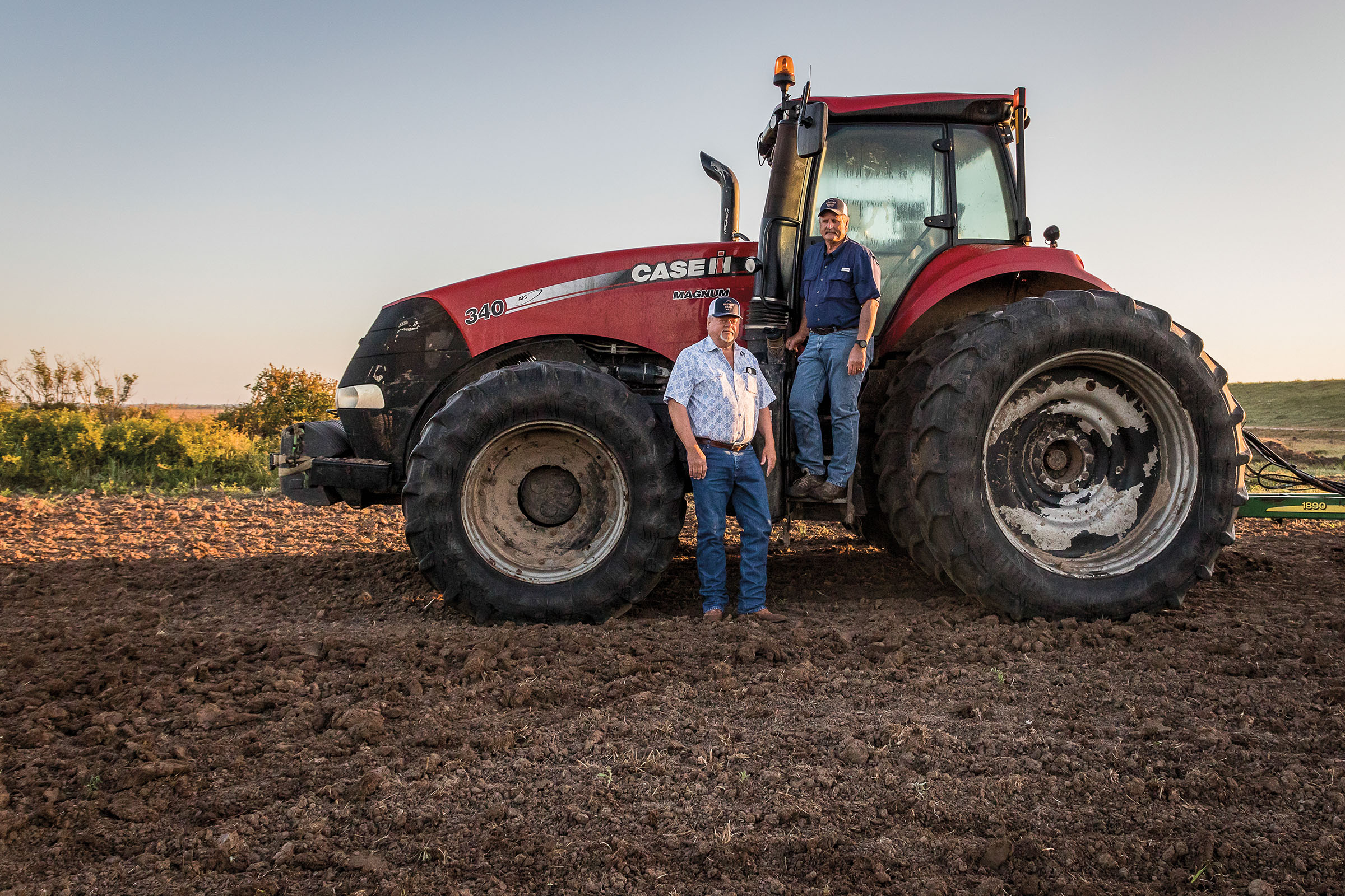 The owners of Harvest Grain Mills pose by a red tractor