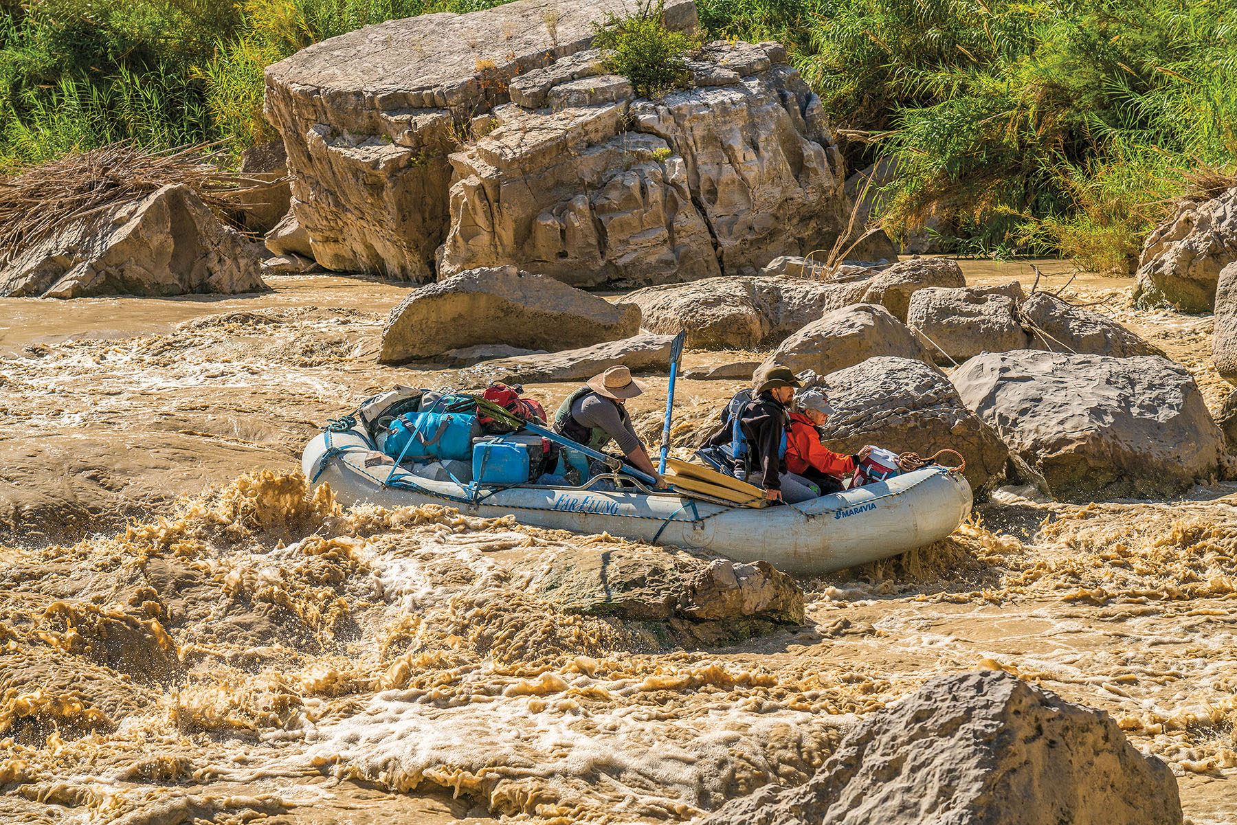 A raft navigates between rocks and rapids on the Rio Grande