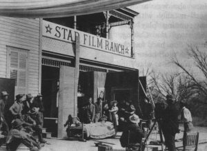 The Star Film Ranch crew films a scene outside against the side of the ranch house