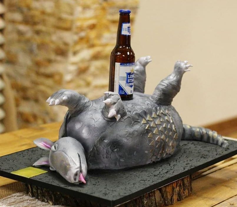 Armadillo cake on its back with a beer bottle on its stomach