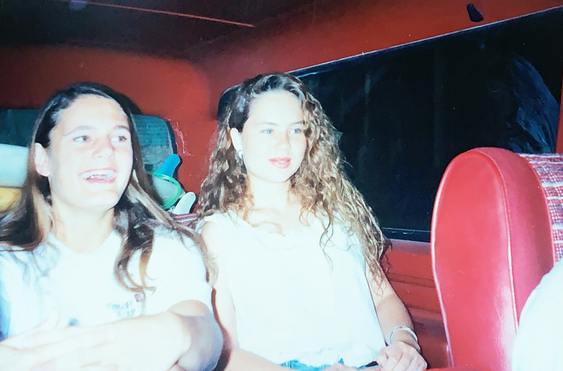 Two teenage girls in the backseat of a car