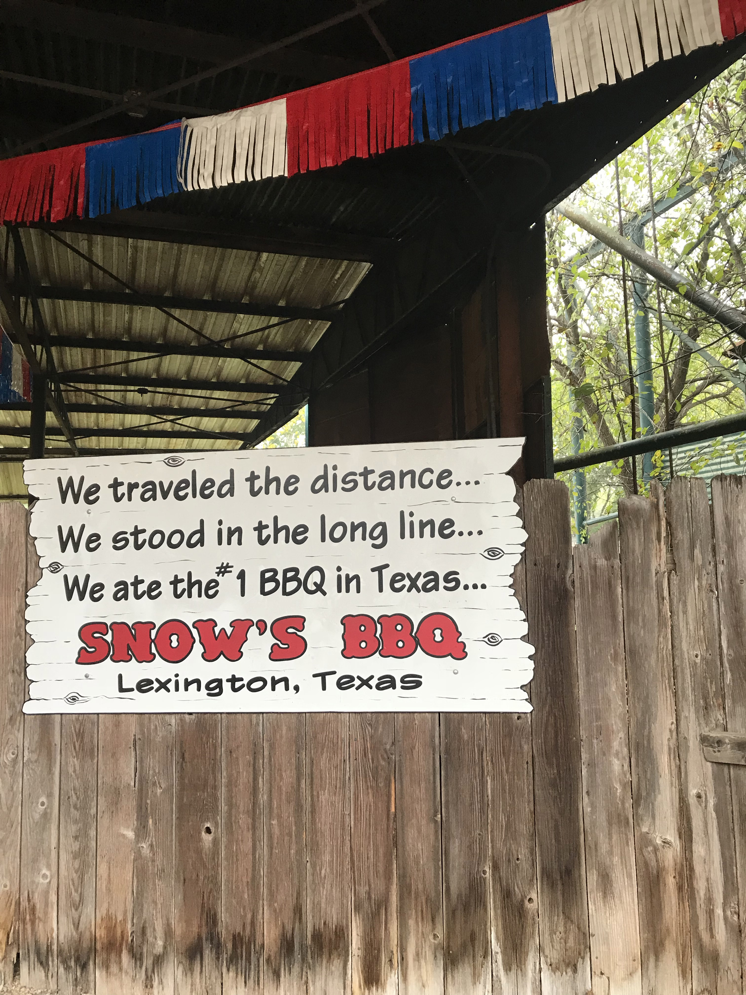 A sign at Snow's BBQ in Lexington Texas that reads "We traveled the distance. We stood in the long line. We ate the #1 BBQ in Texas. Snow's BBQ.