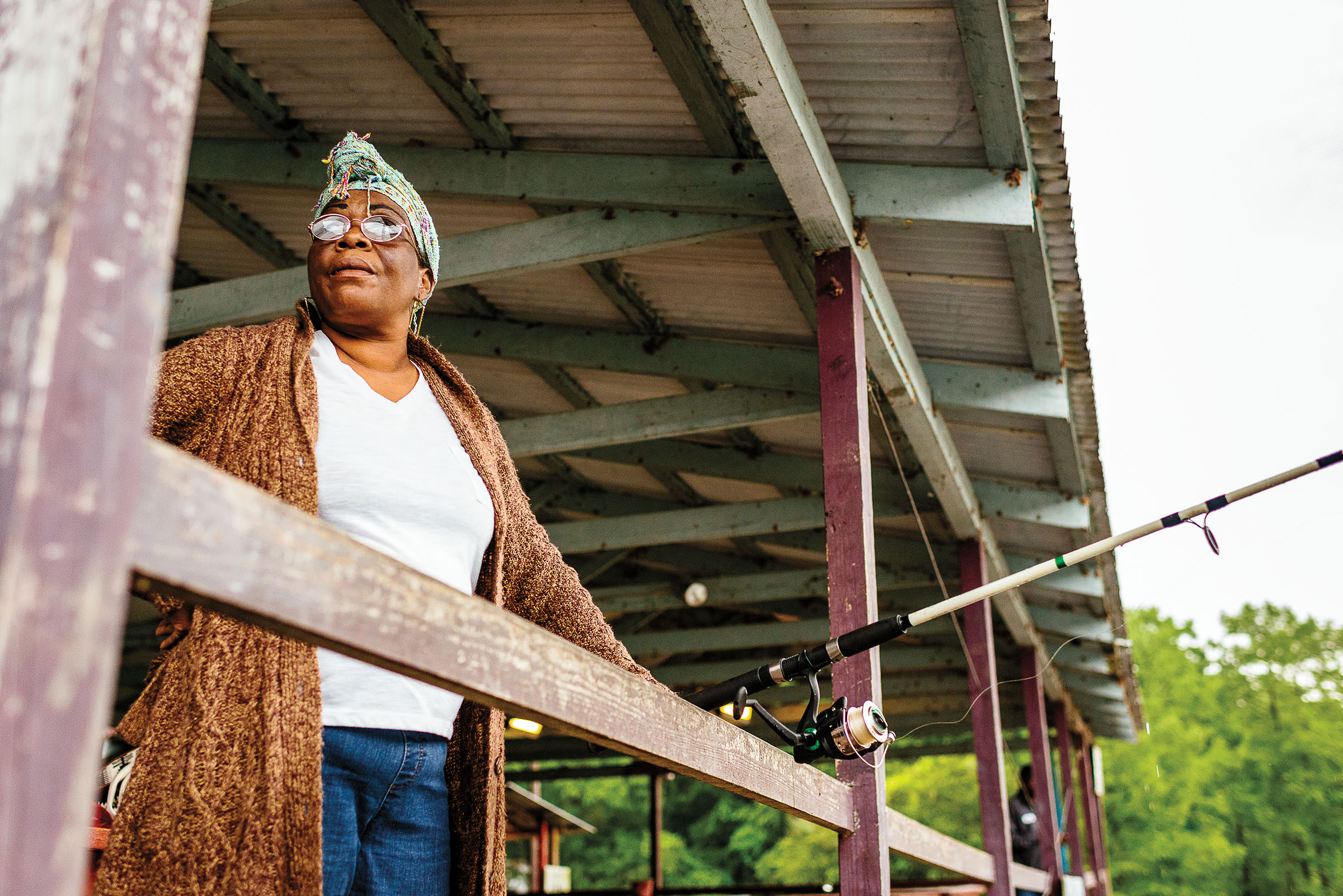 A woman stands with a fishing reel while on a dock on Caddo Lake