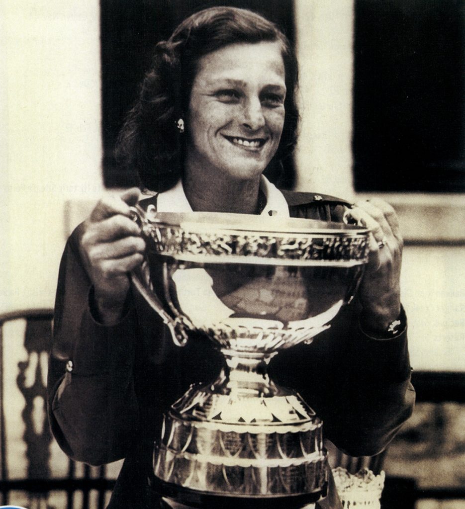 Babe Zaharias holding the 1947 British Women's Amateur Golf Championship trophy