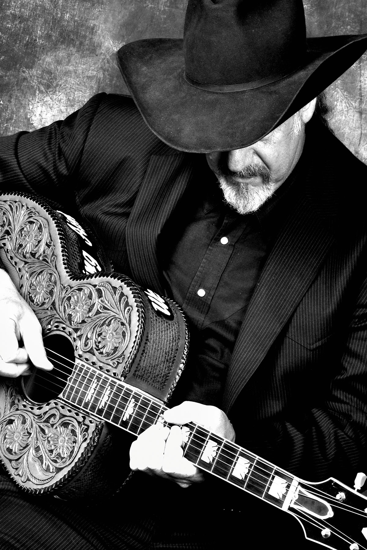 A black and white picture of Ray Benson playing guitar in 2009