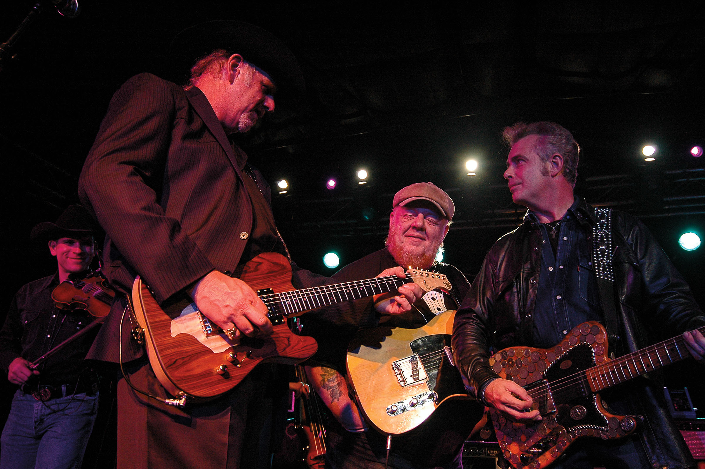 Benson, Redd Volkaert, and Dale Watson play guitars under stage lights