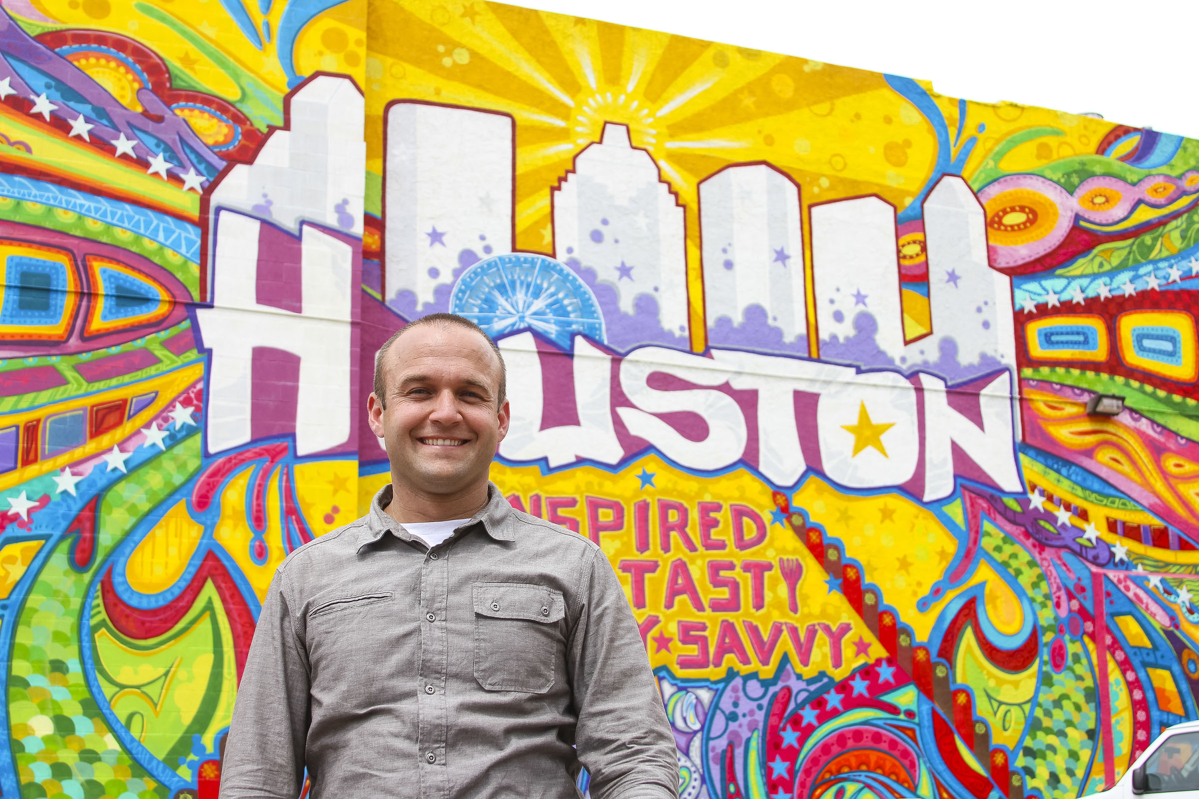 Chet Garner stands in front of a mural that says Houston Texas