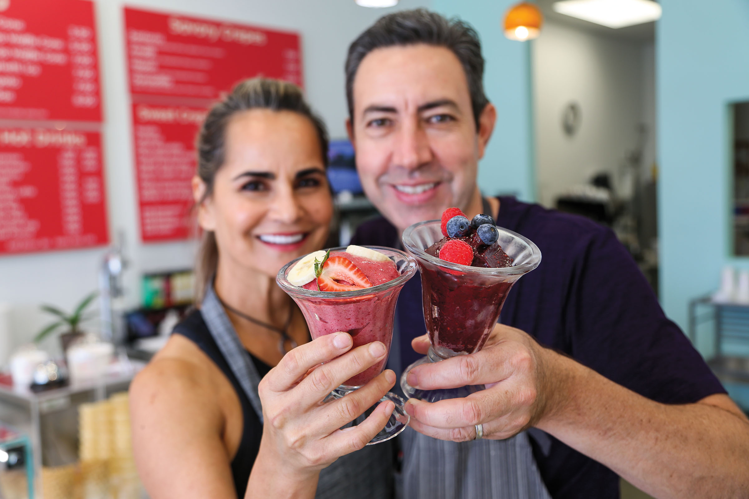 The owners of Zenzero pose with fruit and gelato in a glass dish