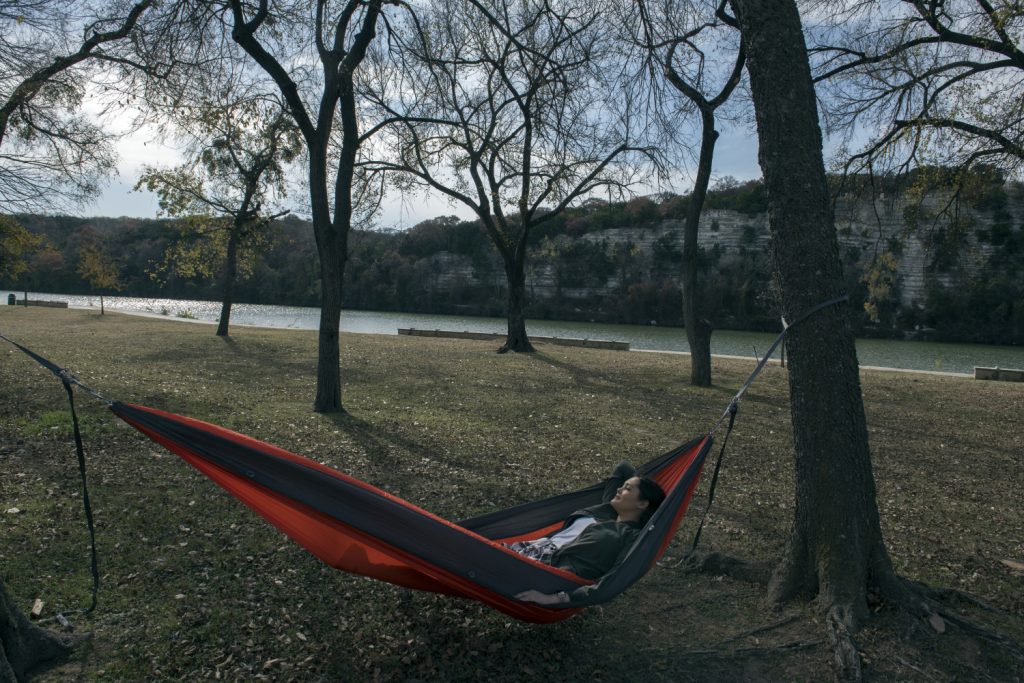 A woman relaxes in a hammock at Brazos Park East in Waco