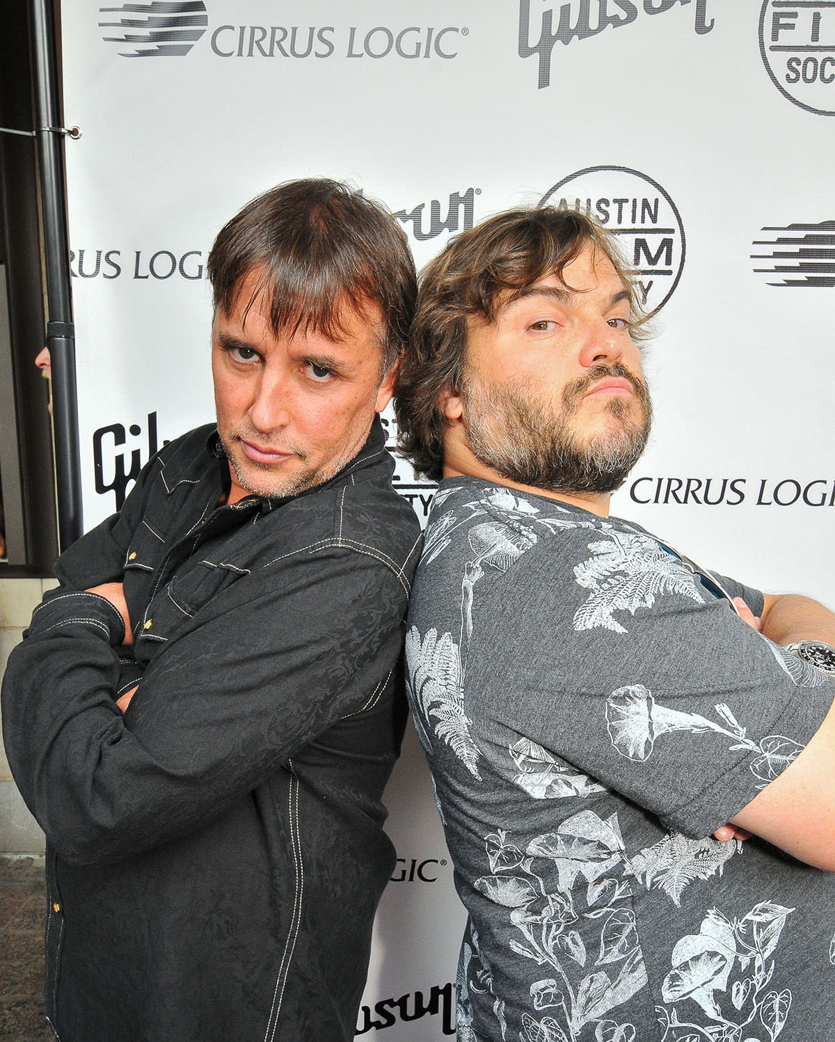 Linklater stands with arms crossed back to back with actor Jack Black