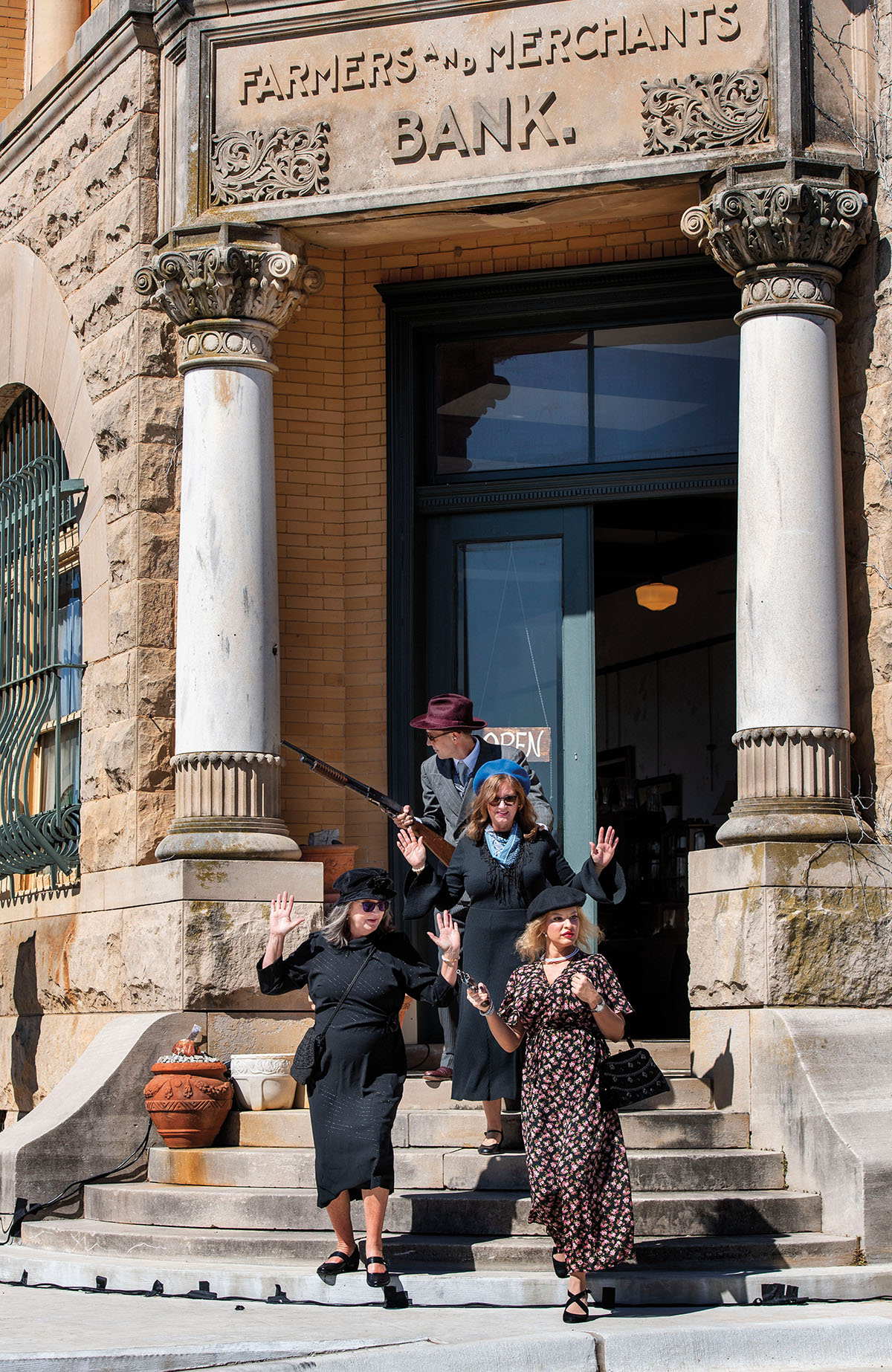 Actors in front of a bank recreate an iconic scene from Bonnie & Clyde