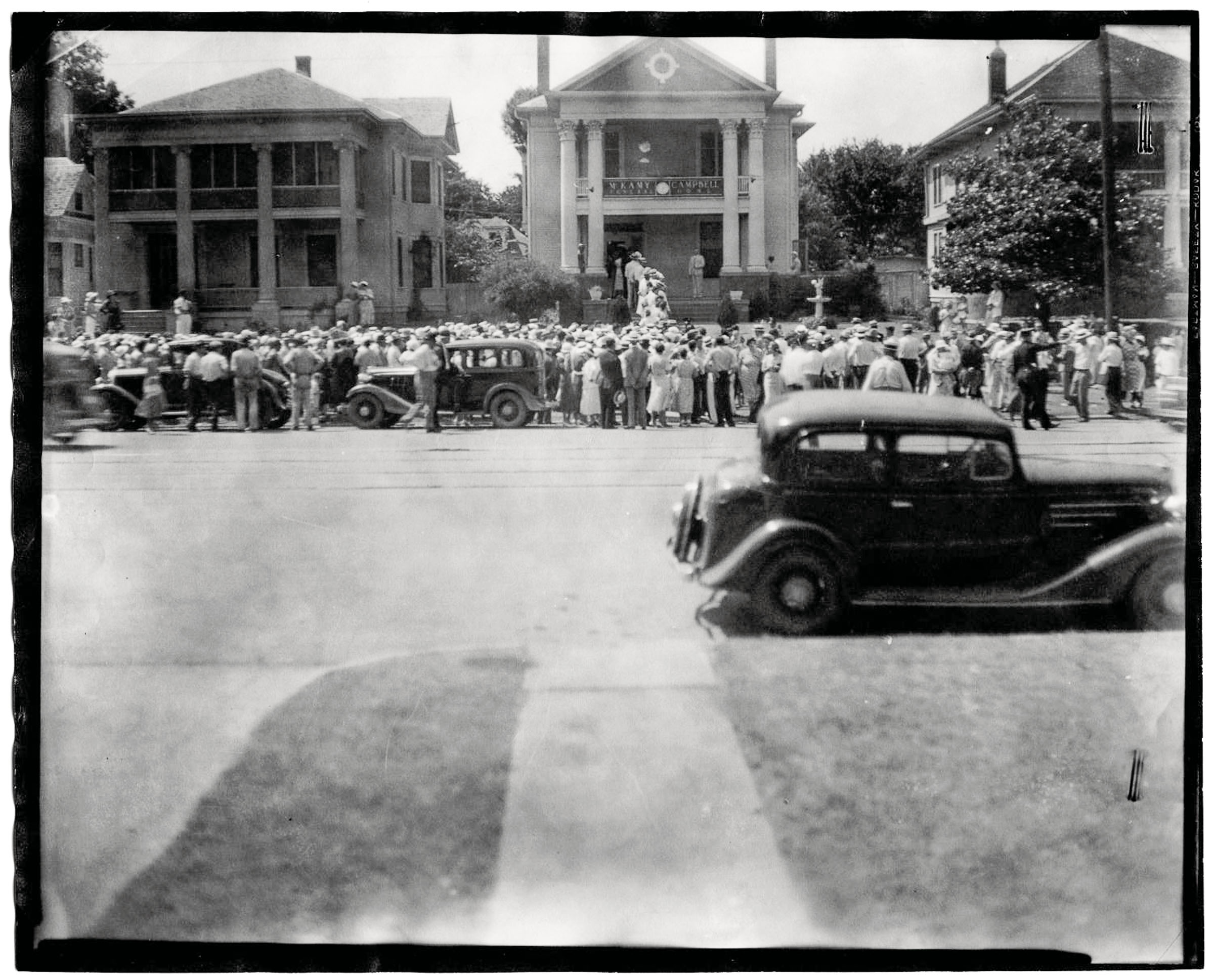 A car drives by a crowd of people at Bonnie's funeral