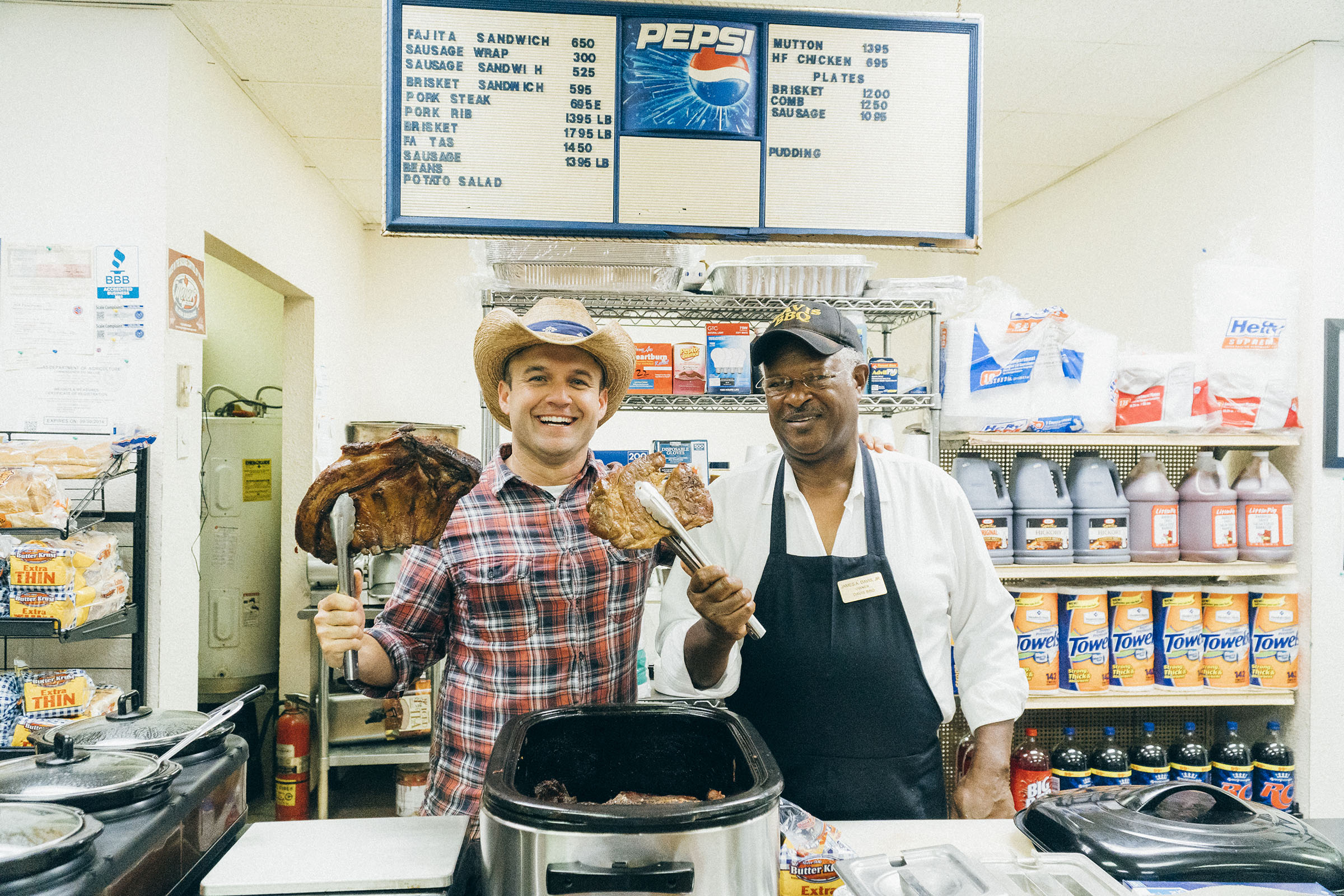 Daytripper Chet Garner holds up two pieces of barbecue in a store in Taylor