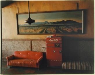 Photo of a Coke machine and red couch
