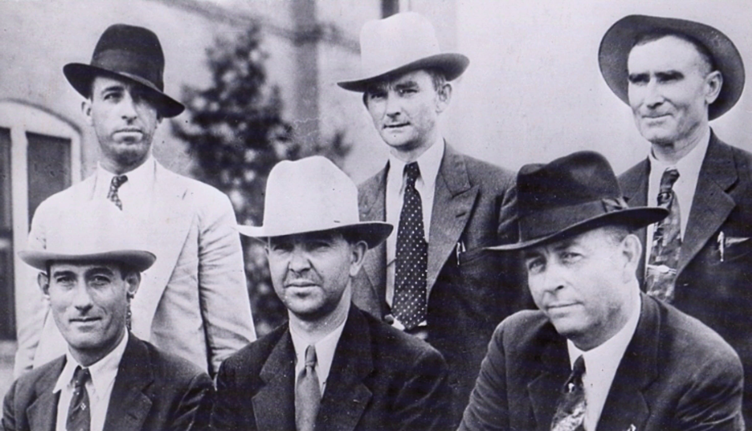 A group of men in hats pose in this historic photo