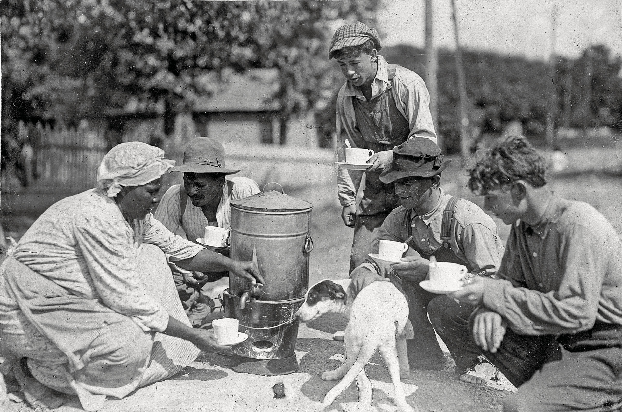 People collect coffee from a tin carafe into white teacups