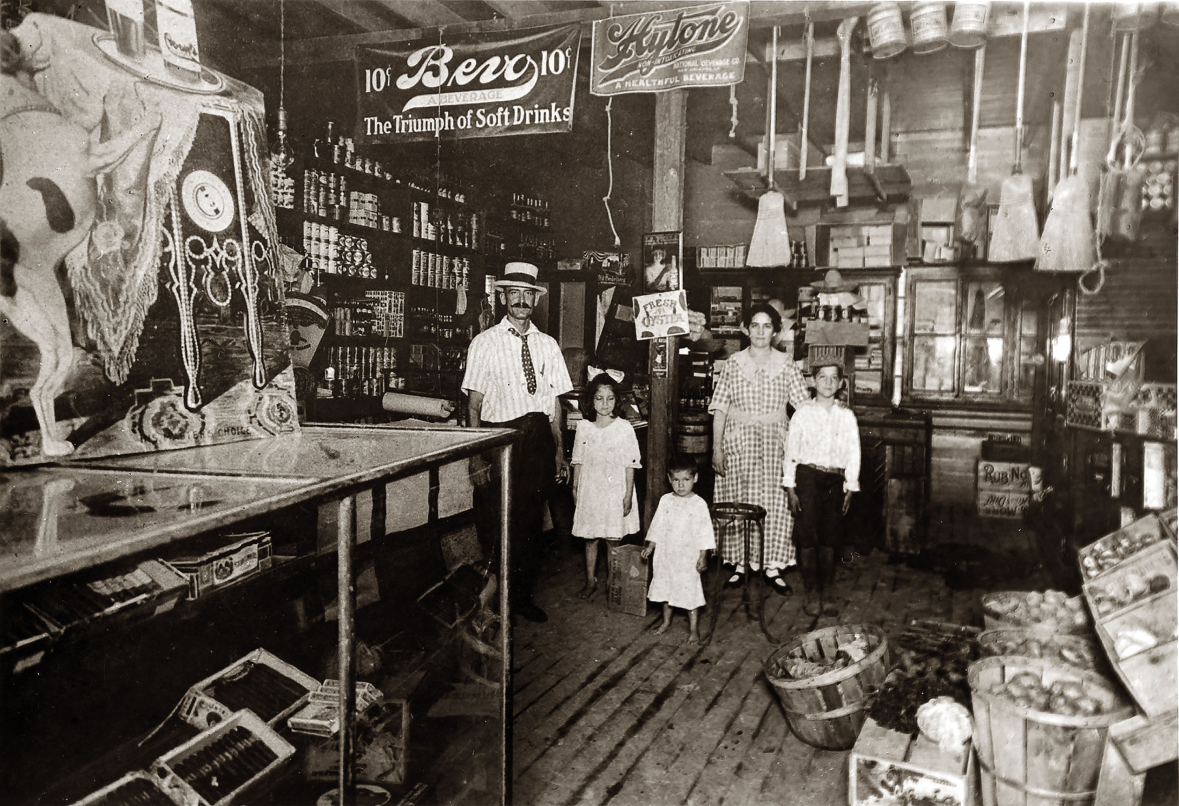 A family stands inside of a grocery store crowded with products and logos