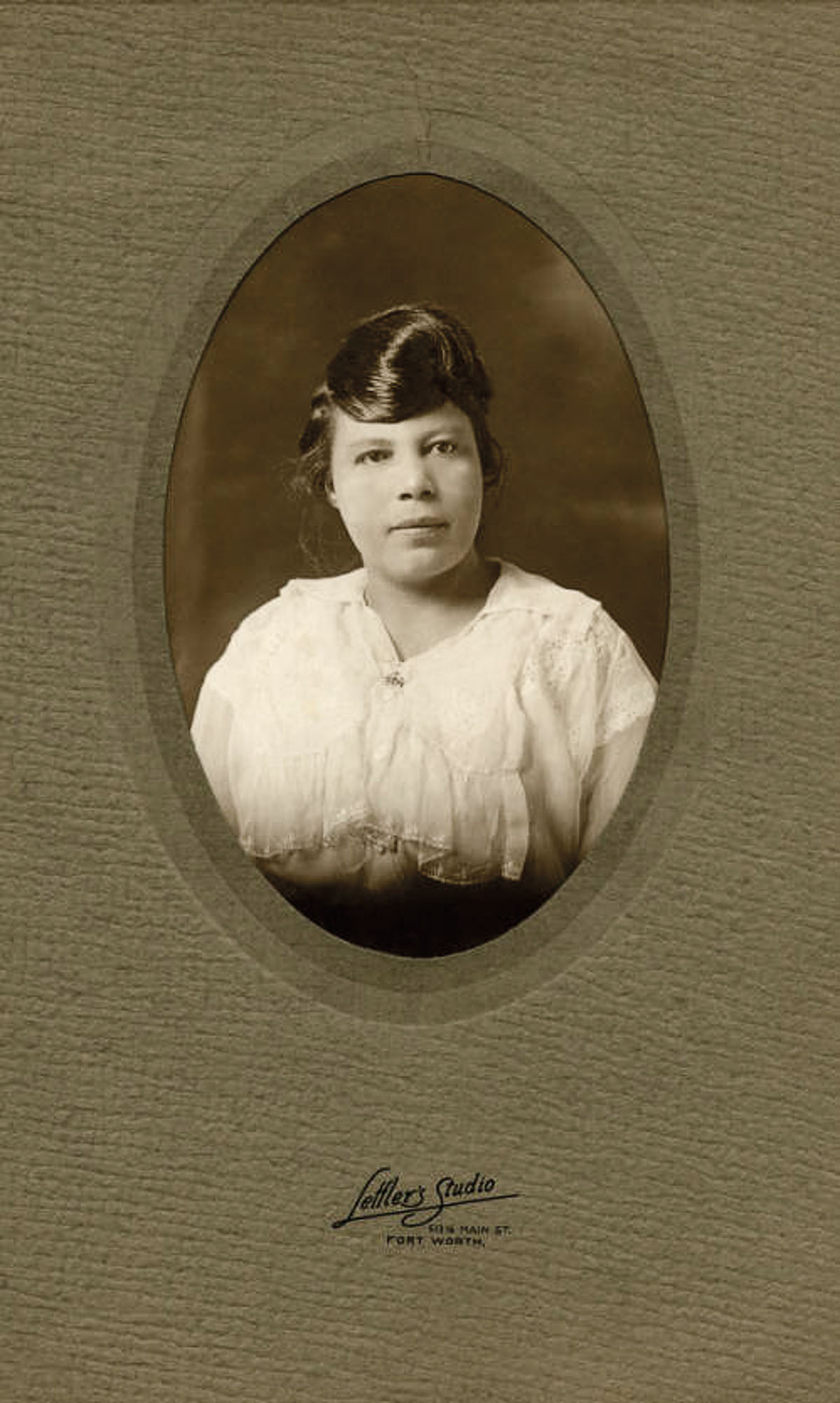 A portrait of a young woman surrounded by a green border